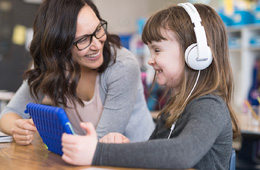 Teacher helping student on a tablet