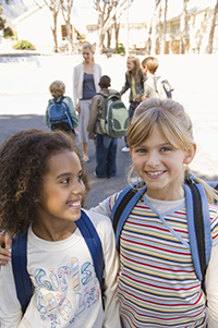 students with backpacks in the school yard
