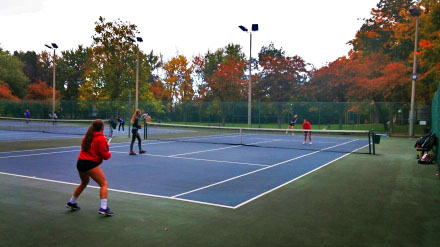 A set of girls are playing tennis on the ground